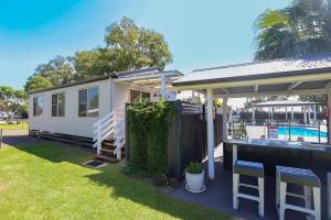 a tiny house with a deck and a swimming pool at Kingaroy Holiday Park in Kingaroy