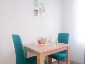 a wooden table with chairs and a bowl of fruit on it at SweetHome in Nha Trang