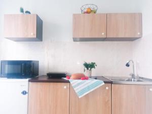 a kitchen with wooden cabinets and a sink and a bowl of fruit at SweetHome in Nha Trang