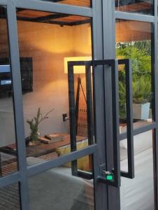 uma vista através de uma porta de vidro de um quarto com plantas em Guest Tiny House - lake side em Montevidéu
