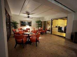 プラヤ・コロナドにあるGOLF CORONADO LUXURY MANGO SUITE PRIVATE POOL FEE INCLUDEDのオレンジ色の椅子とテーブルが備わるレストラン