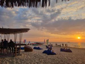 een groep mensen op een strand bij zonsondergang bij SOLÉA Hotel GrandWorld Phu Quoc in Phu Quoc