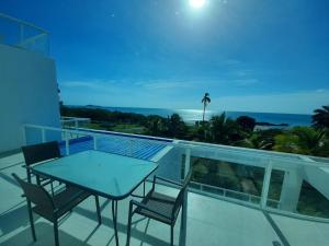 balcón con mesa, sillas y vistas al océano en Villas de Playa Blanca, Rooftop Vista al Mar en Río Hato