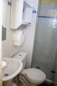 a bathroom with a toilet and a sink and a shower at Comfort House in Santa Marta