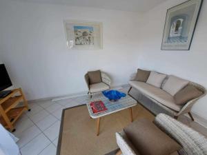 sala de estar con sofá, sillas y mesa en Appartement Marseillan, 3 pièces, 4 personnes - FR-1-326-806, en Marseillan
