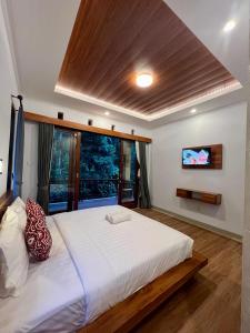 Un dormitorio con una gran cama blanca y una ventana en Rare House en Ubud