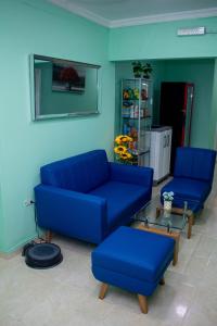 a living room with two blue couches and a table at Comfort House in Santa Marta