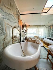 a large white bath tub in a bathroom at Nomado Boutique Hotel in Ulaanbaatar