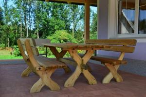 einem Picknicktisch aus Holz und einer Bank vor einem Fenster in der Unterkunft Haus Karin Seidl in Neumarkt in Steiermark