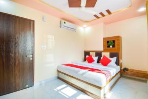 een slaapkamer met een bed met rode kussens bij OYO Flagship Hotel Classico Inn in Jaipur