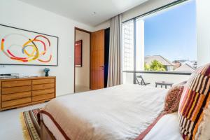 a bedroom with a bed and a large window at Mandala Residences in Canggu