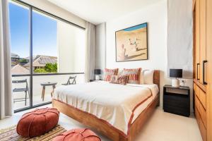 a bedroom with a large bed and a large window at Mandala Residences in Canggu