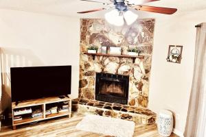 a living room with a stone fireplace with a flat screen tv at Mandarin Cheerful 2 Bedroom Townhouse w/fireplace in Jacksonville