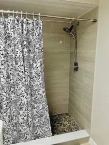 a shower with a black and white shower curtain at Mandarin Cheerful 2 Bedroom Townhouse w/fireplace in Jacksonville +11 photos