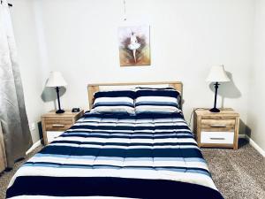 1 dormitorio con 1 cama con rayas azules y blancas en Mandarin Cheerful 2 Bedroom Townhouse w/fireplace, en Jacksonville