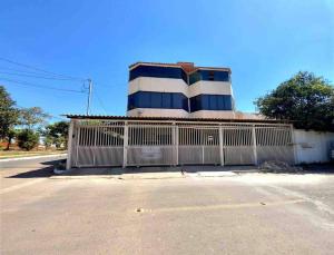 a building with a gate in front of a street at 2 Quartos Completo Barato in Brasilia