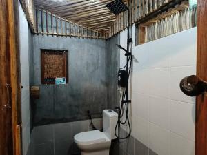a bathroom with a white toilet in a room at Cahaya Wooden Studio in Pantai Cenang