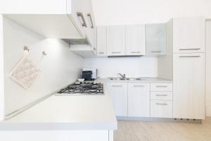 uma cozinha branca com armários brancos e um fogão em [Schio Centro storico] Casa nel cuore della città em Schio