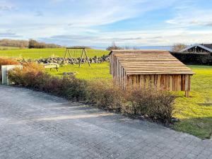 małą drewnianą szopę na polu z huśtawką w obiekcie 8 person holiday home in Faaborg w mieście Bøjden
