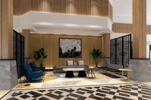 a lobby with a couch and a table and chairs at Sheraton Jakarta Soekarno Hatta Airport in Tangerang
