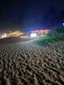 a sandy beach at night with a building in the background at Gokarna Ocean Tree in Gokarna