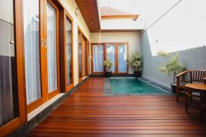 an indoor pool in a house with a wooden deck at Villa Maha IV in Dalung