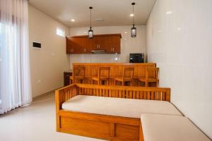 a bedroom with a wooden bed and a kitchen at Villa Maha IV in Dalung