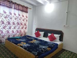 a bedroom with a bed with red pillows at Betab Valley Guest House Pahalgam in Pahalgām