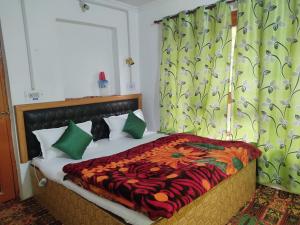 a bedroom with a large bed with green curtains at Betab Valley Guest House Pahalgam in Pahalgām
