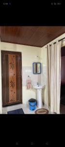 a small bathroom with a sink and a toilet at Brindavan cottage in Madikeri