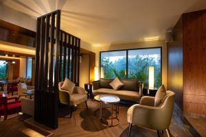 a lobby with couches and chairs and a large window at The Oasis Mussoorie - A Member of Radisson Individuals in Mussoorie