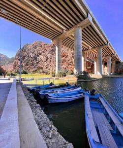 two boats are docked under a bridge at Wadi shab chalet in Ţīwī