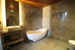 a bathroom with a tub and a sink and a toilet at Villa Taru Jagat in Saba +38 photos