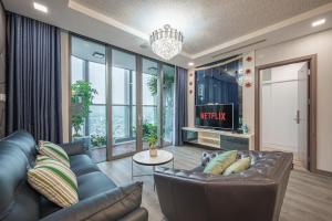 a living room with a couch and a tv at LANMARK 81 Enigma Residences in Ho Chi Minh City