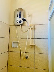 a shower in a bathroom with a phone on the wall at Boholala hostel in Panglao