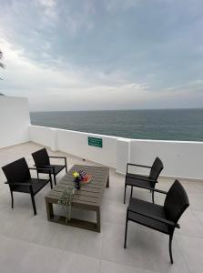 Ţīwī的住宿－Wadi shab chalet，一个带桌椅的海景阳台