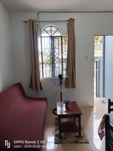 een woonkamer met een rode bank en een tafel bij Townhouse near PH Arena - Ethan's Transient in Marilao