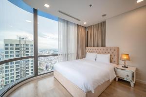 a bedroom with a large bed and large windows at LANMARK 81 Enigma Residences in Ho Chi Minh City