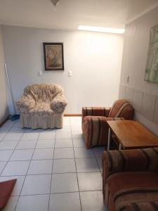 ein Wohnzimmer mit einem Sofa und einem Stuhl in der Unterkunft Hospedaje JM in Chillán
