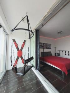 カップ・ダグドにあるCap d'Agde Naturist Héliopolis 81のベッドルーム1室(赤いベッド1台、大きな窓付)