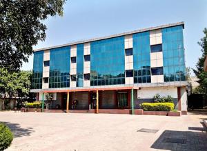 um grande edifício de vidro com muitas janelas em HOTEL RAJMAHAL GREEN em Bhiwadi