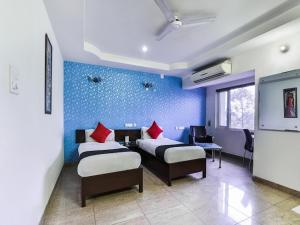 um quarto com 2 camas e uma parede azul em HOTEL RAJMAHAL GREEN em Bhiwadi