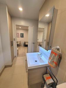 uma casa de banho com um lavatório branco e um espelho. em Sky tower just next DOOR em Auckland
