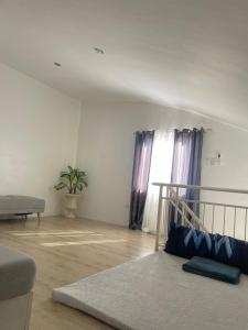 a living room with a bed and a window at The Family Suite at the Mactan Airport in Pusok