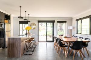 a kitchen and dining room with a wooden table and chairs at 44onRoaring - in the Huon Valley in Surveyors Bay