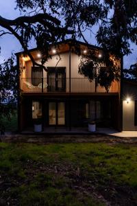 a house with a balcony at night at 44onRoaring - in the Huon Valley in Surveyors Bay