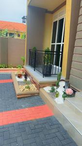 Vera's Luxury Home Near Speke Resort Munyonyo في Munyonyo: شرفة منزل عليها نباتات