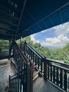 a wooden balcony with a view of the forest at Munduk Tjeraki House in Munduk