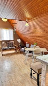 a living room with wooden ceilings and tables and benches at Casa María in Siguatepeque