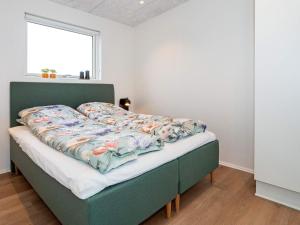 a bed with a green frame in a room with a window at Holiday home Lemvig XLVII in Lemvig